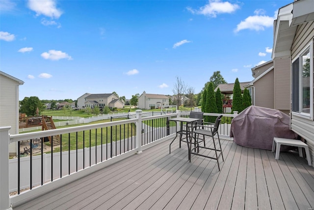 deck with a residential view, grilling area, and a yard