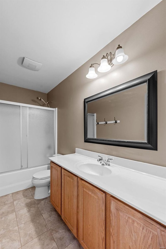 bathroom with toilet, shower / bath combination with glass door, tile patterned flooring, and vanity