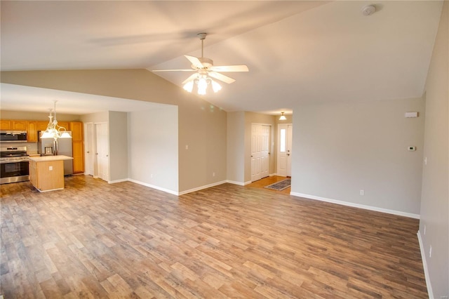 unfurnished living room with ceiling fan with notable chandelier, lofted ceiling, and light hardwood / wood-style floors