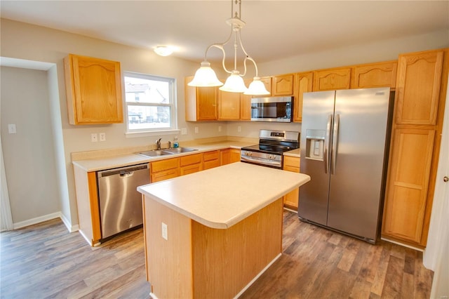 kitchen featuring dark hardwood / wood-style floors, pendant lighting, sink, a center island, and stainless steel appliances