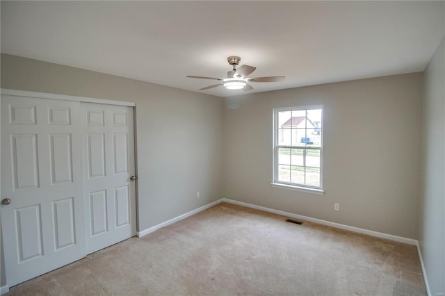 carpeted empty room featuring ceiling fan