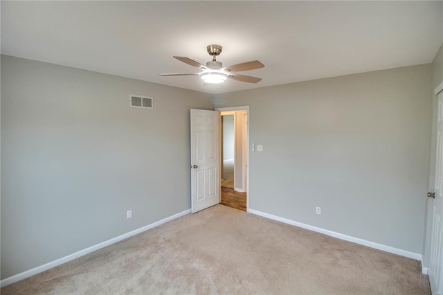 carpeted spare room featuring ceiling fan