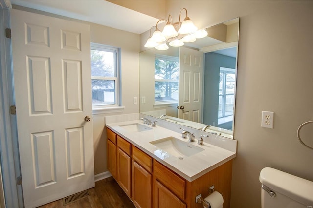 bathroom featuring vanity, toilet, a chandelier, and wood-type flooring