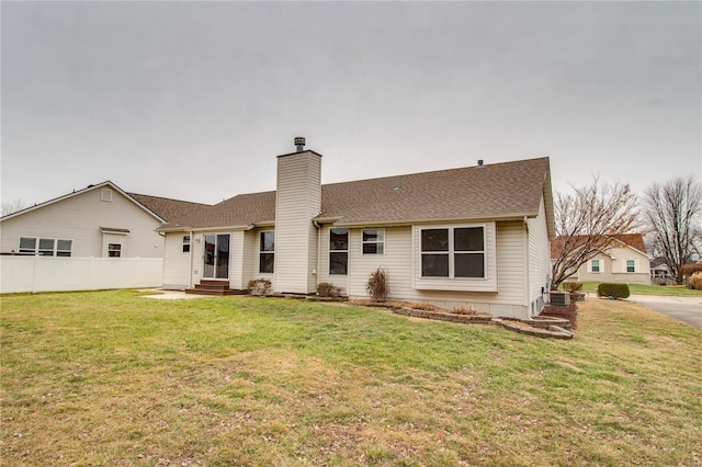 rear view of property with a lawn