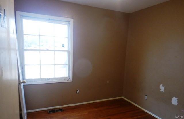 empty room with dark hardwood / wood-style flooring