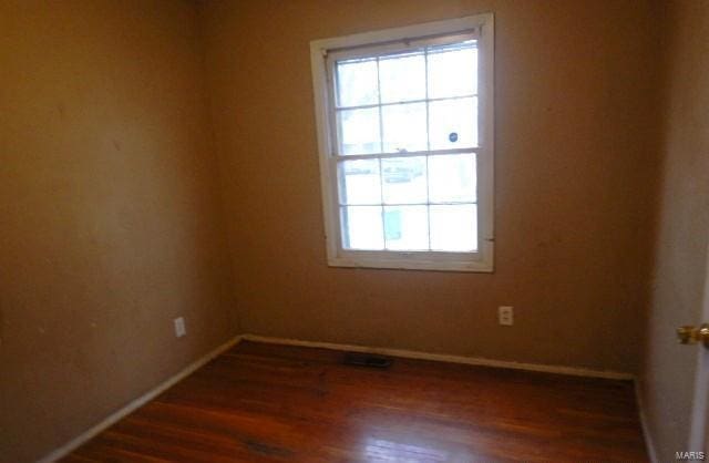 empty room with dark hardwood / wood-style flooring