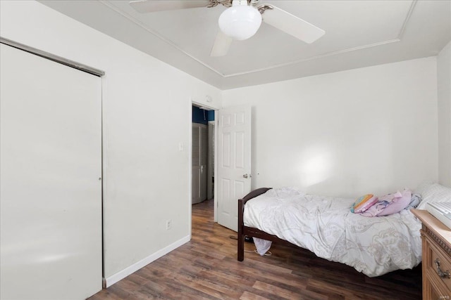 bedroom with dark wood-type flooring, ceiling fan, and a closet