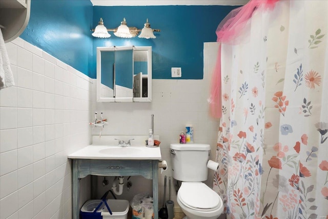 bathroom with a shower with curtain, toilet, sink, and tile walls