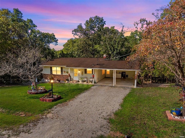 ranch-style home with a carport and a yard