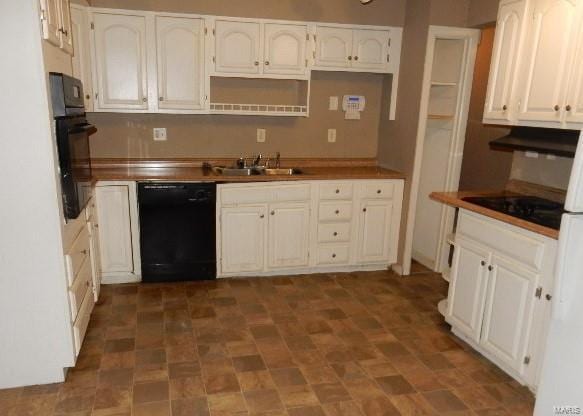 kitchen with white cabinetry, sink, black appliances, and butcher block counters