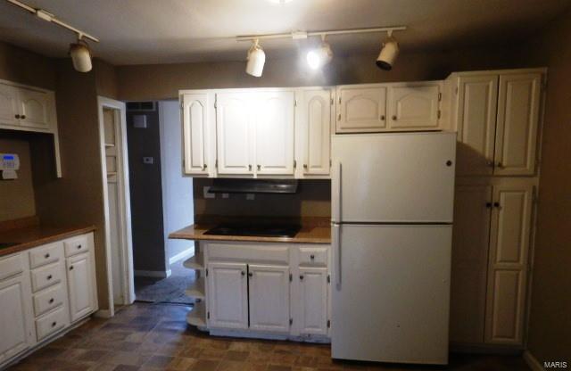 kitchen featuring white refrigerator, white cabinetry, and black electric stovetop