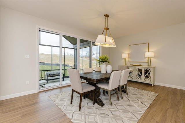 dining area featuring light wood-type flooring and baseboards