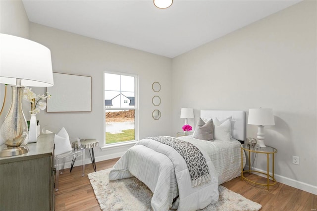 bedroom with light wood finished floors and baseboards