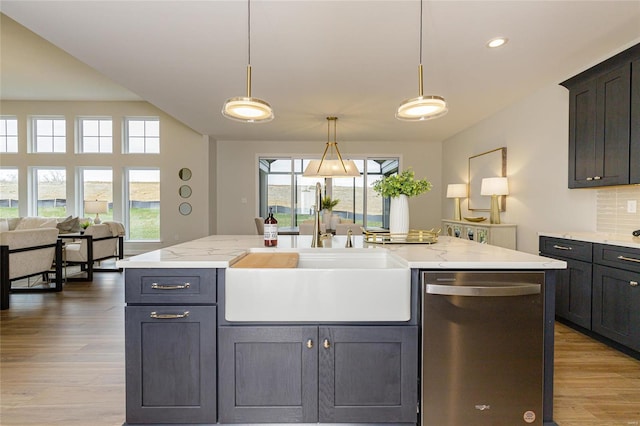 kitchen with a sink, light wood-style floors, open floor plan, hanging light fixtures, and dishwasher