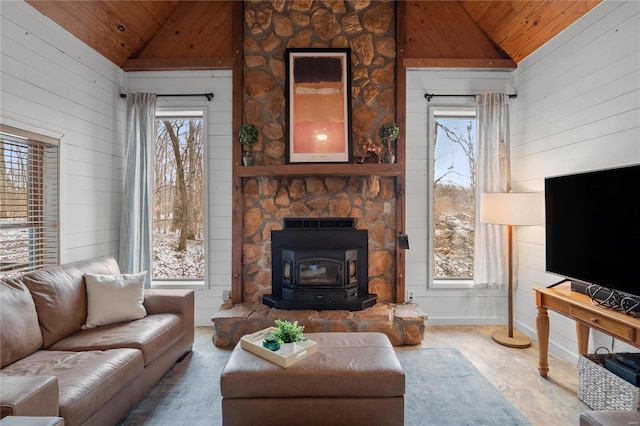 living room featuring wood ceiling, vaulted ceiling, and a wood stove