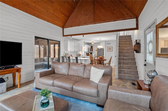 living room featuring visible vents, stairway, wood ceiling, wooden walls, and high vaulted ceiling