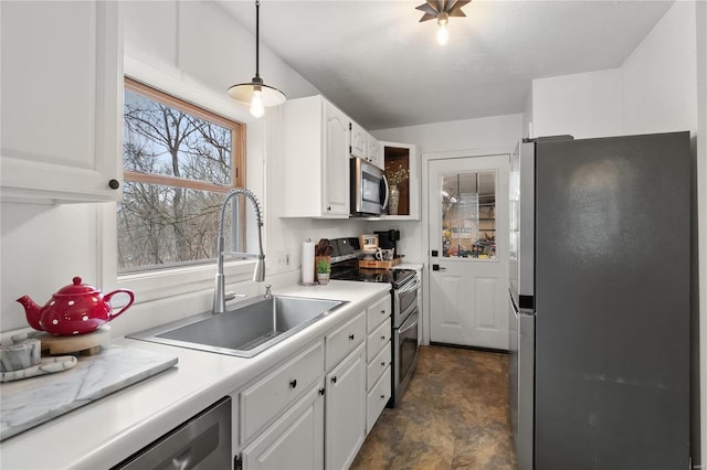 kitchen featuring stainless steel appliances, a sink, light countertops, and white cabinets