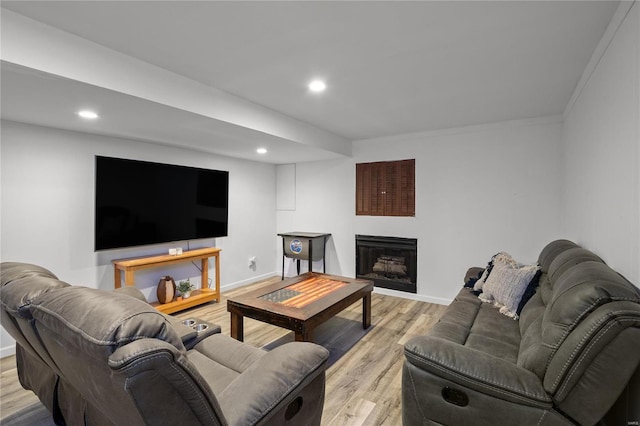 living area with light wood-style floors, recessed lighting, a fireplace, and baseboards