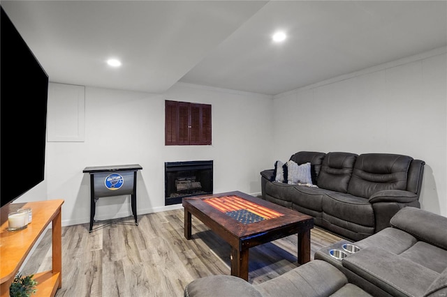 living area featuring light wood-style flooring, a fireplace, baseboards, and recessed lighting