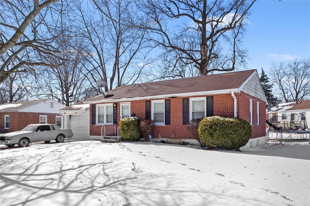 view of front facade with brick siding and an attached garage