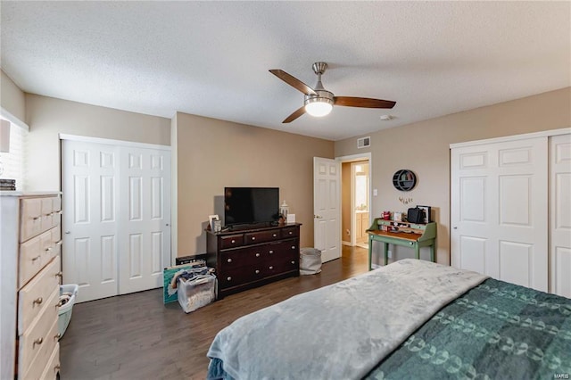 bedroom with ceiling fan, a textured ceiling, and dark hardwood / wood-style flooring