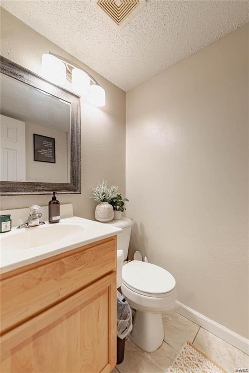 bathroom with vanity, a textured ceiling, tile patterned floors, and toilet