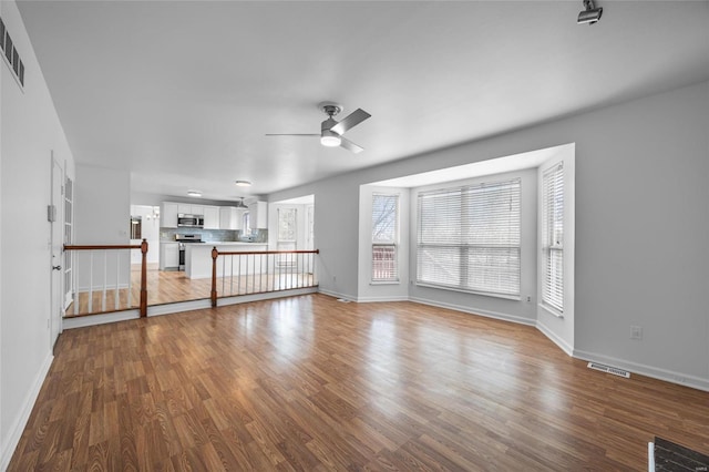 unfurnished living room featuring wood-type flooring and ceiling fan