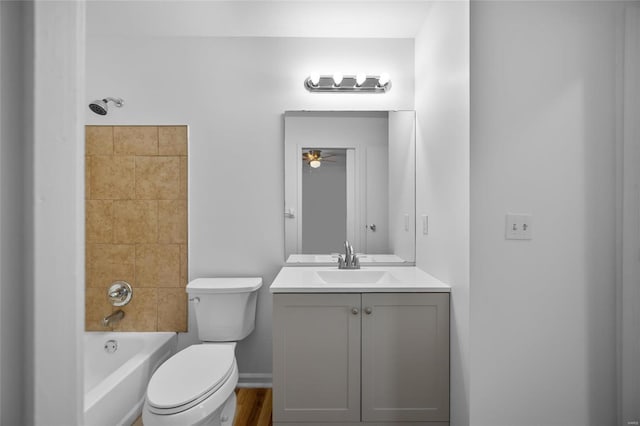 full bathroom featuring tiled shower / bath combo, vanity, ceiling fan, and toilet