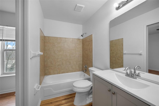 full bathroom with tiled shower / bath combo, wood-type flooring, vanity, and toilet