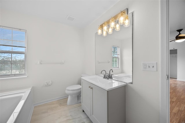 bathroom featuring vanity, a bathing tub, and toilet