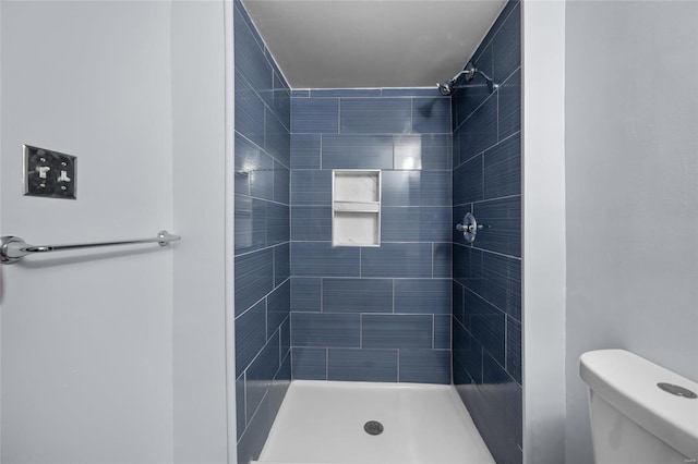 bathroom featuring toilet and tiled shower