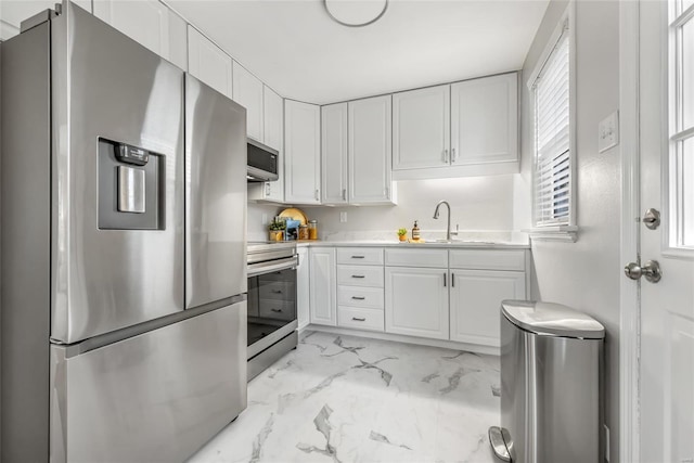 kitchen featuring stainless steel appliances, sink, and white cabinets