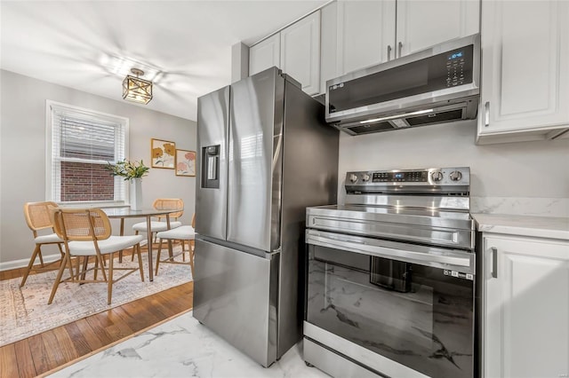 kitchen featuring stainless steel appliances and white cabinets