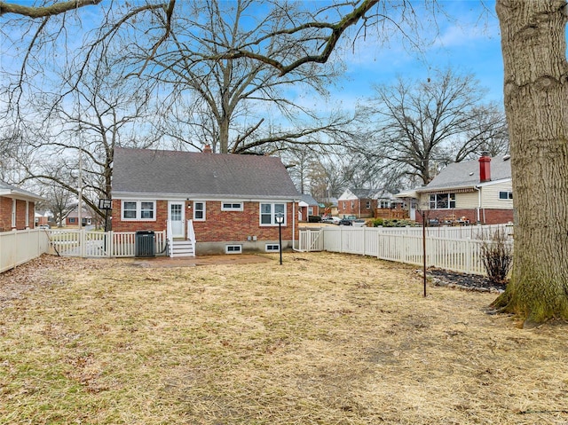 rear view of property with cooling unit and a yard