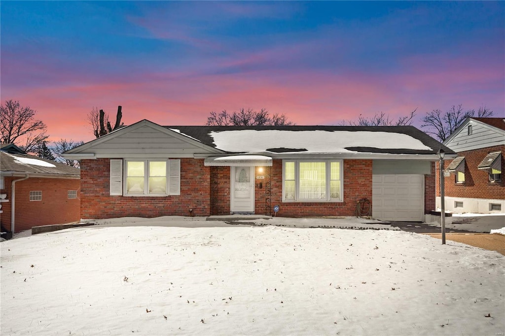 ranch-style home featuring a garage and brick siding