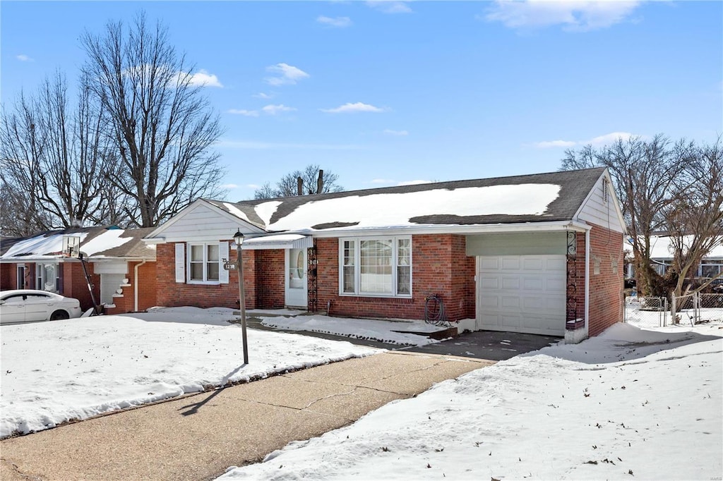 ranch-style home featuring a garage and brick siding