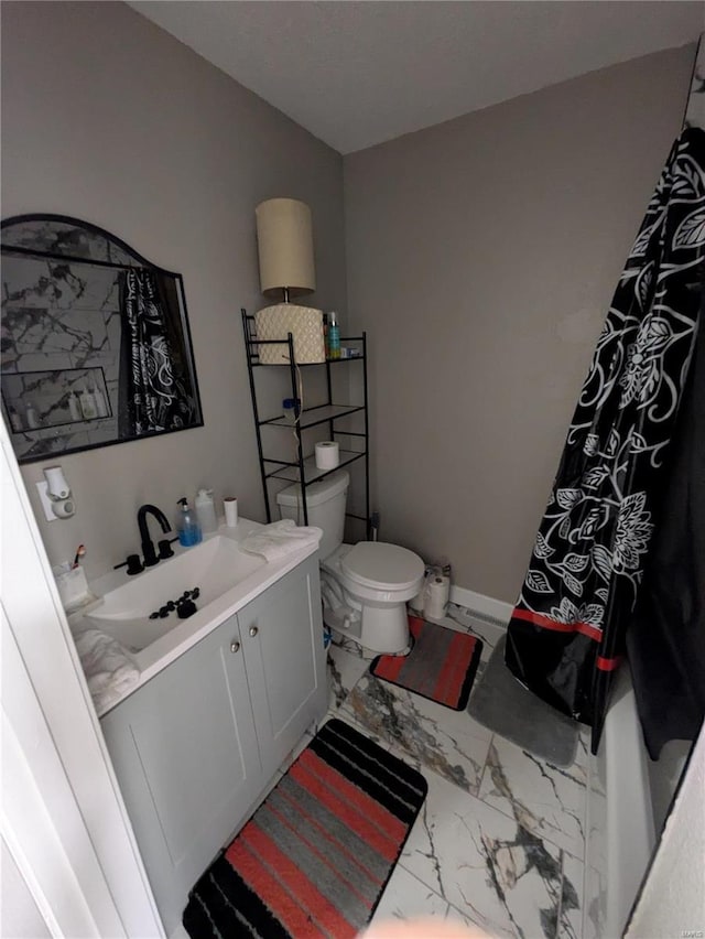 bathroom featuring curtained shower, toilet, vanity, baseboards, and marble finish floor