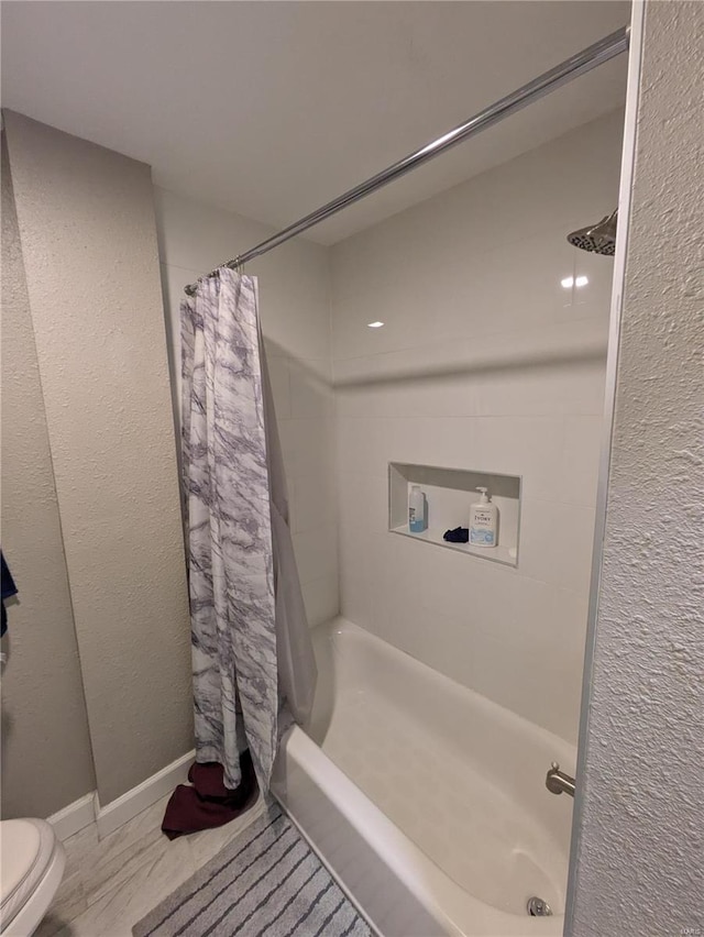 bathroom featuring toilet and baseboards