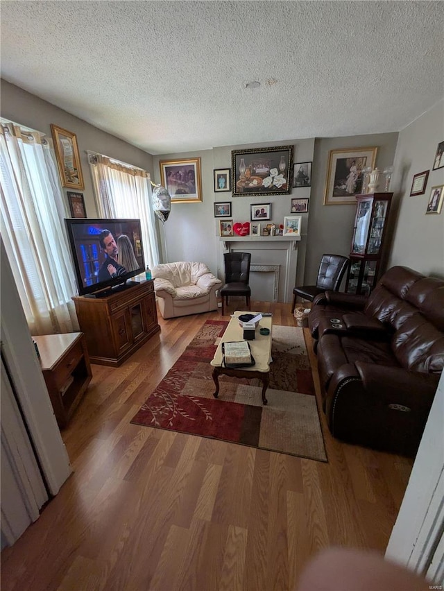 living area with a textured ceiling and wood finished floors