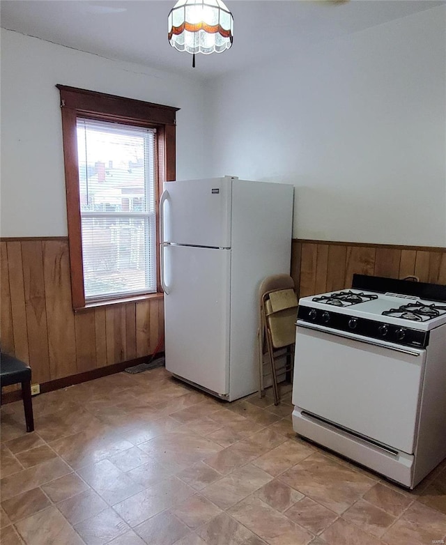 kitchen featuring white appliances and wooden walls