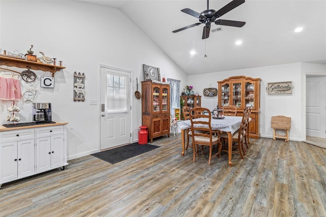 dining room featuring high vaulted ceiling, ceiling fan, and light hardwood / wood-style flooring