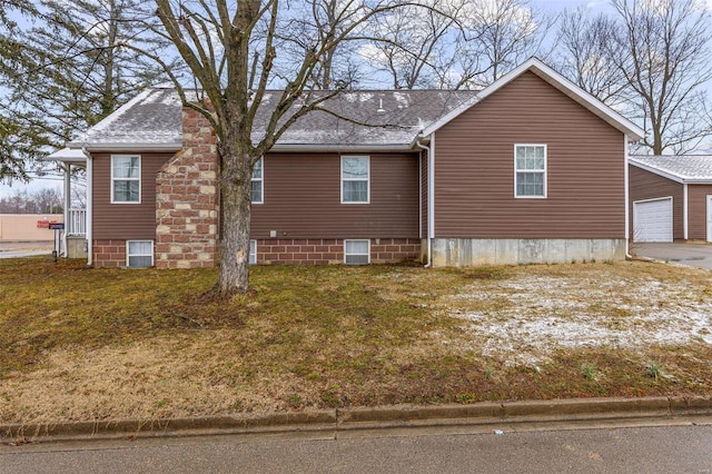 view of side of property featuring a garage, an outbuilding, and a lawn