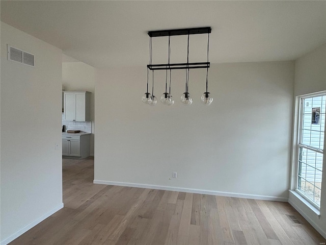 unfurnished dining area with a wealth of natural light and light hardwood / wood-style floors