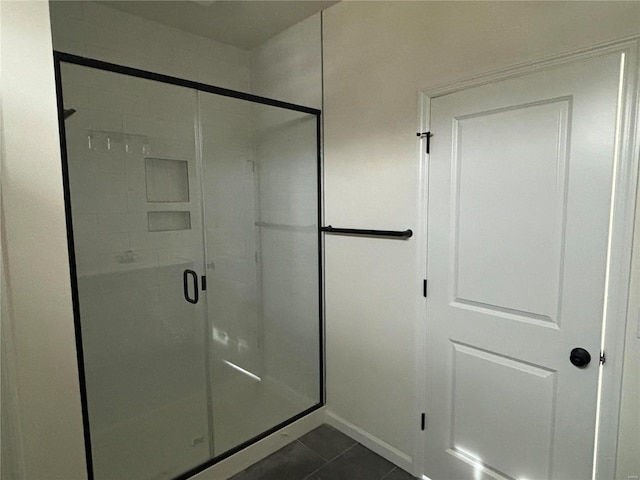 full bathroom with tile patterned flooring and a shower stall