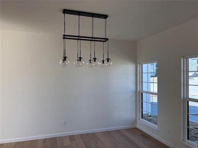 unfurnished dining area with visible vents, wood finished floors, and baseboards