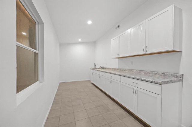 kitchen featuring recessed lighting, white cabinets, light countertops, and baseboards