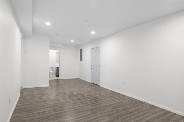 unfurnished room with baseboards, wood finished floors, electric panel, and recessed lighting