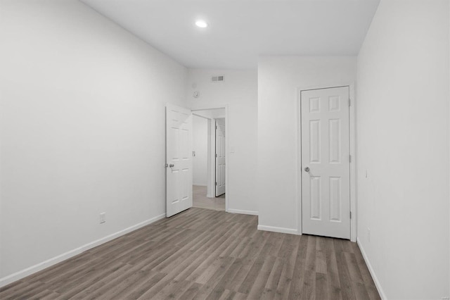 unfurnished bedroom featuring recessed lighting, wood finished floors, visible vents, and baseboards