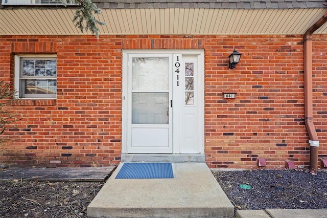 doorway to property featuring brick siding