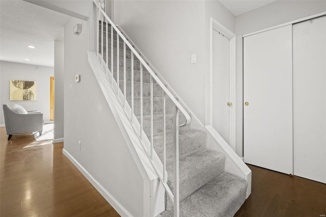 stairs featuring recessed lighting, wood finished floors, and baseboards